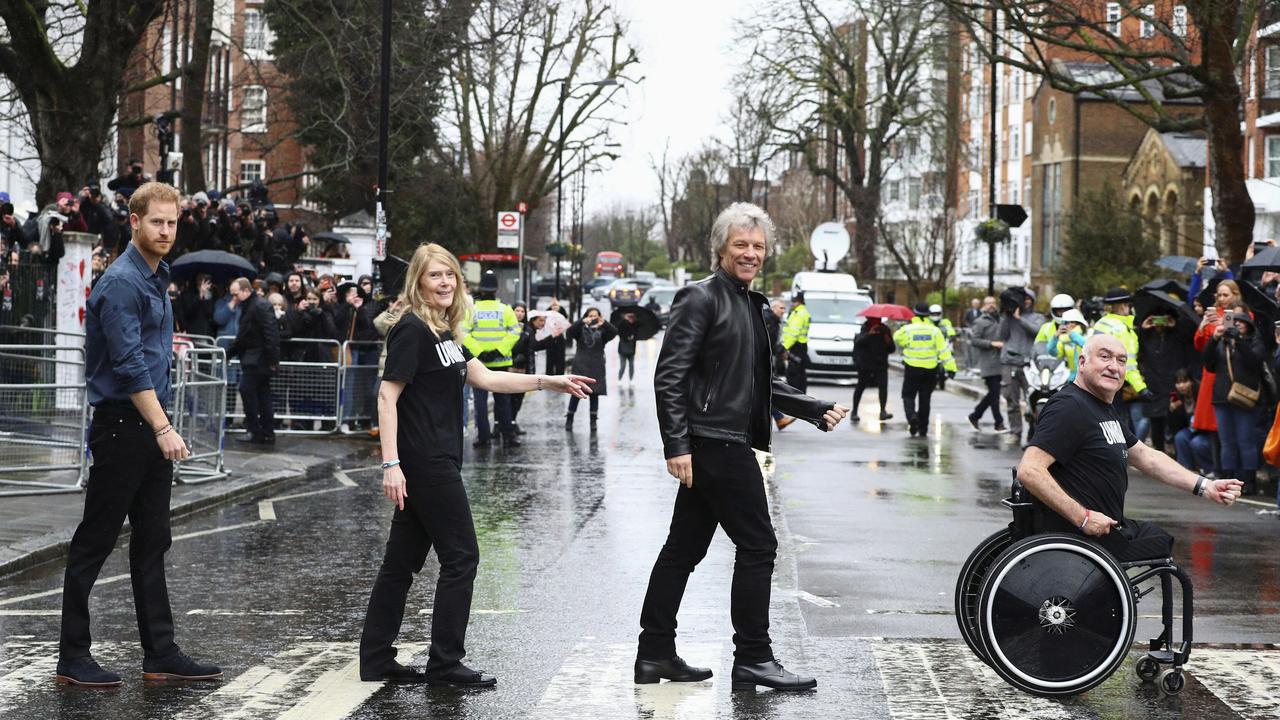 Britain's Prince Harry, Jon Bon Jovi and members of the Invictus Games Choir walk on the famous zebra crossing outside the Abbey Road Studios London, Friday, Feb. 28. They are recording a special single in aid of the Invictus Games Foundation. Picture: Hannah McKay