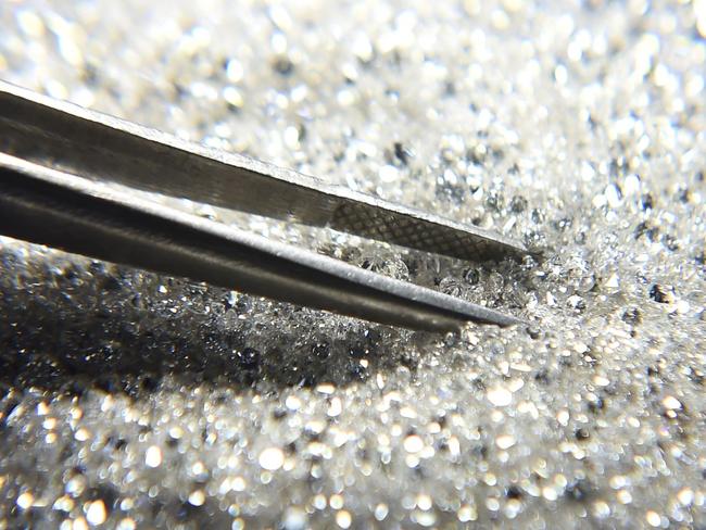 An Indian worker sifts diamonds at a diamond cutting and polishing workshop in Ahmedabad on February 6, 2020. - Gujarat's diamond industry to face a loss of around Rs 8,000 crore as Hong Kong, its major export destination, has declared a state of emergency due to the coronavirus outbreak in China, local media reported. (Photo by SAM PANTHAKY / AFP)