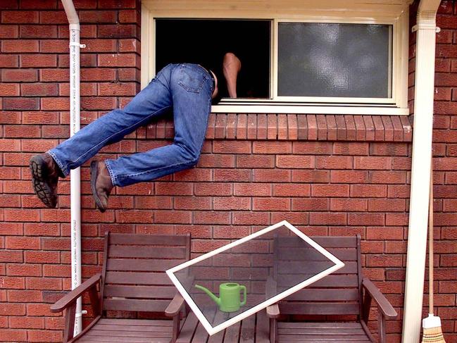 Generic photograph of a burglar thief breaking into a house through an unlocked window. burglary theft larceny. PIRATE: 28/02/2001.