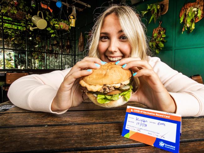 Kirsten Evans tucks into her free first vaccine burger. Picture: NIGEL HALLETT