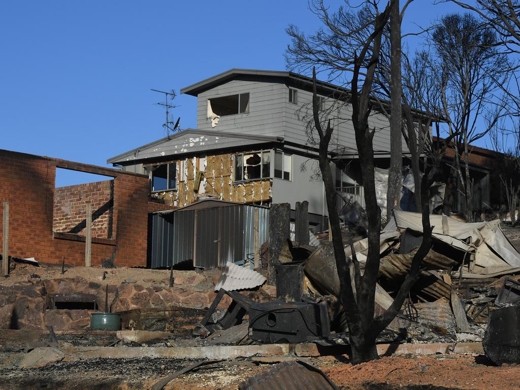 Some of the more than 70 houses and businesses destroyed by a bushfire in the coastal town of Tathra, Monday, March 19, 2018. RFS and NSW Fire and Rescue continue to mop up and douse smouldering homes after a devastating fire ripped through the community yesterday and overnight. (AAP Image/Dean Lewins)