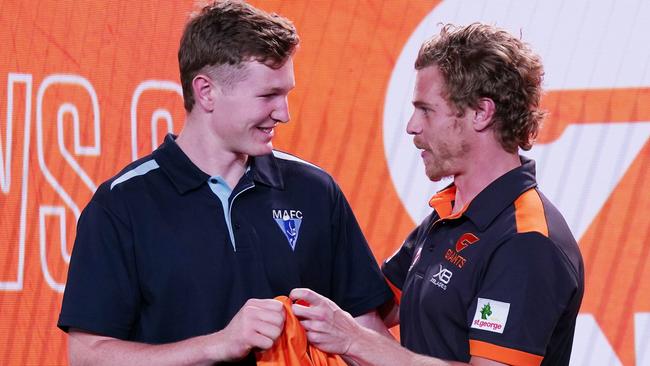 Tom Green (left) receives his guernsey from Adam Kennedy on draft night. Picture: AAP Image/Michael Dodge