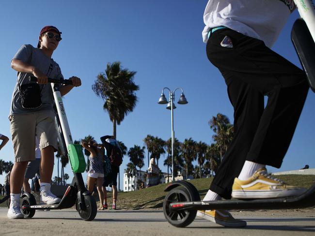 LOS ANGELES, CA - AUGUST 13: People ride Lime shared dockless electric scooters along Venice Beach on August 13, 2018 in Los Angeles, California. Shared e-scooter startups Bird and Lime have rapidly expanded in the city. Some city residents complain the controversial e-scooters are dangerous for pedestrians and sometimes clog sidewalks. A Los Angeles Councilmember has proposed a ban on the scooters until regulations can be worked out.   Mario Tama/Getty Images/AFP == FOR NEWSPAPERS, INTERNET, TELCOS & TELEVISION USE ONLY ==