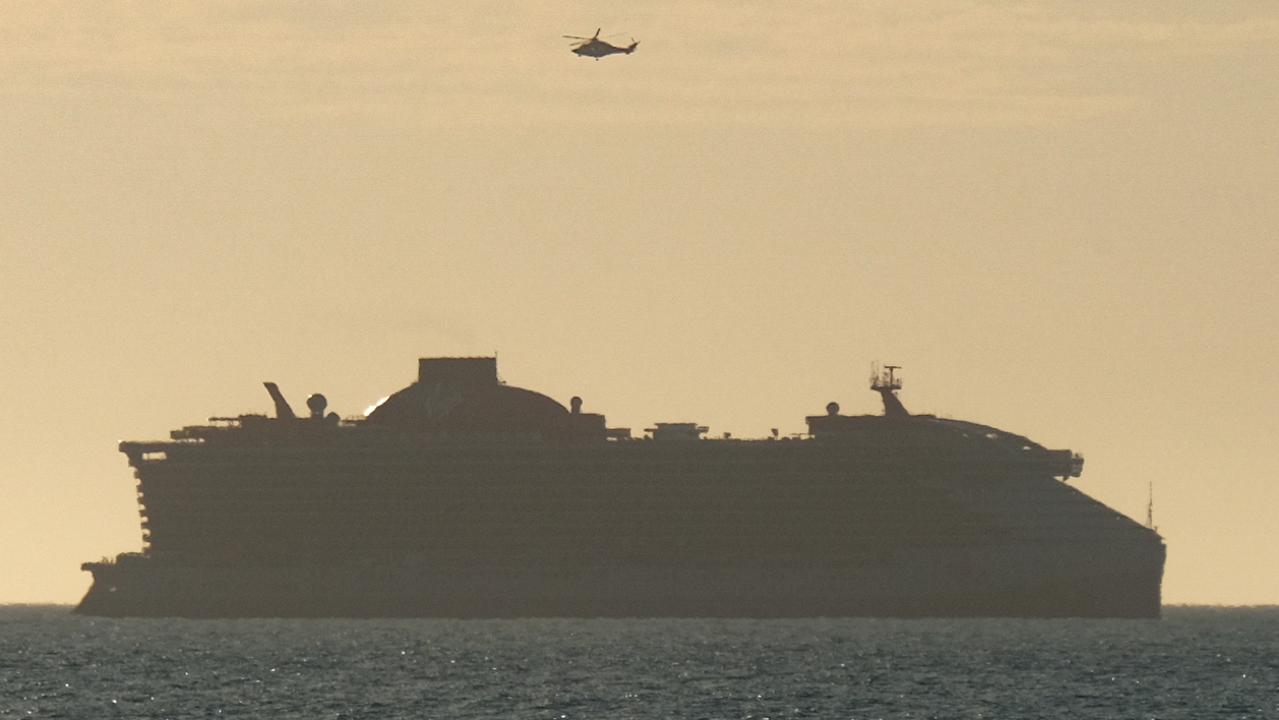 A helicopter hovers above a cruise ship (believed to be a Virgin vessel) off the Surf Coast. A very ill passenger was transported to hospital by air ambulance as early morning beachgoers watched on. Picture: Shaun Viljoen