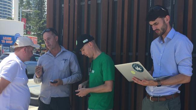 Council officials speak with Lime Director of Government Affairs Mitchell Price following the launch of the e-scooters on the esplanade at Surfers Paradise today.