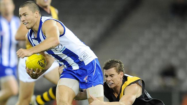 Gavin Urquhart gets tackled by Andrew Collins during his days in the AFL.