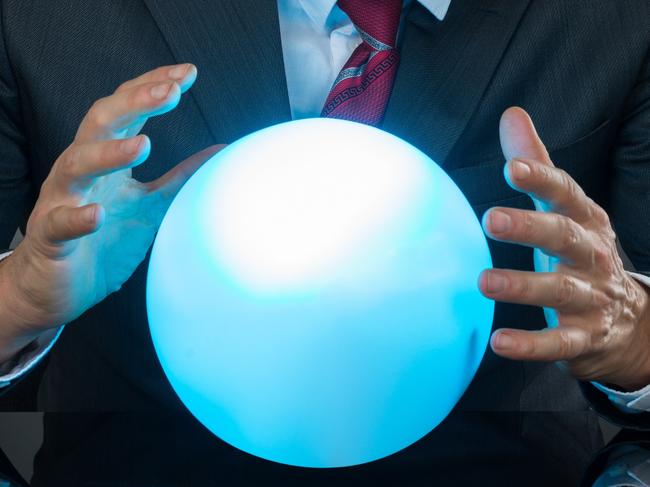 Portrait Of Businessman Predicting Future With Crystal Ball On Desk