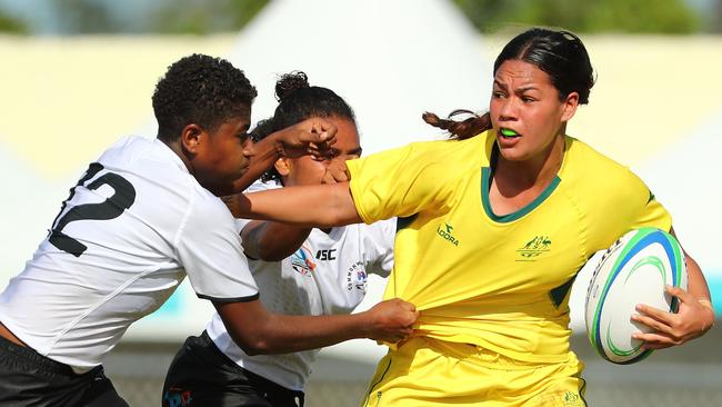 Kennedy Cherrington fends off Fijian defenders during the match between Fiji and Australia in the Girls Rugby Sevens on day 2 of the 2017 Youth Commonwealth Games.