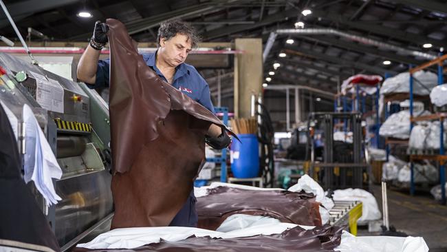 A worker setting whip leather at Packers Leather Tannery at Narangba. Picture Lachie Millard