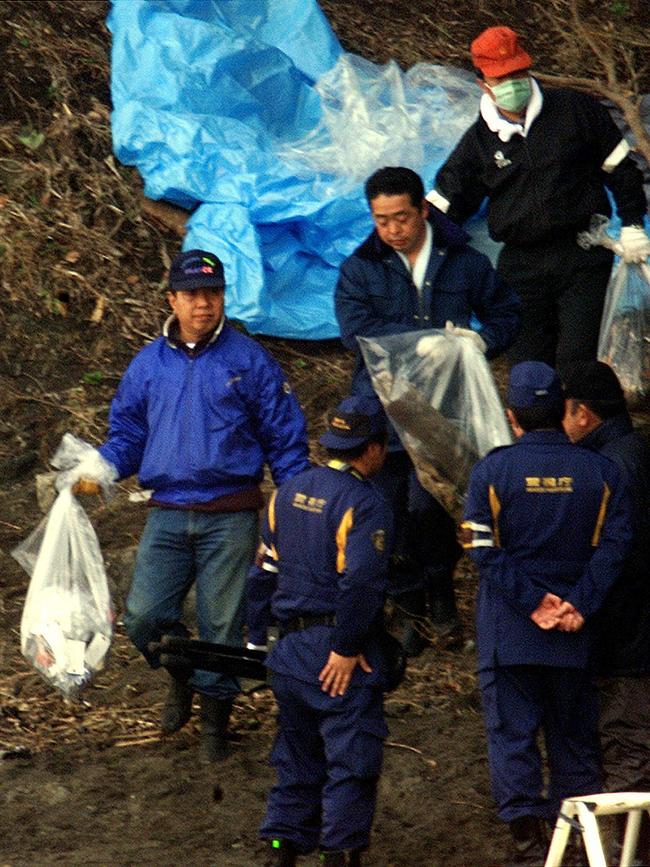 Police carry vinyl bags from cave in Miura, Kanagawa Prefecture where dismembered remains of Lucie Blackman were discovered. Picture: AFP