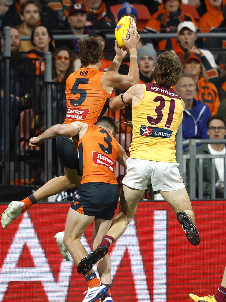 Giants Stephen Coniglio is injured in this marking contest with Aaron Cadman and Brisbane's Harris Andrews. Photo: Phil Hillyard.