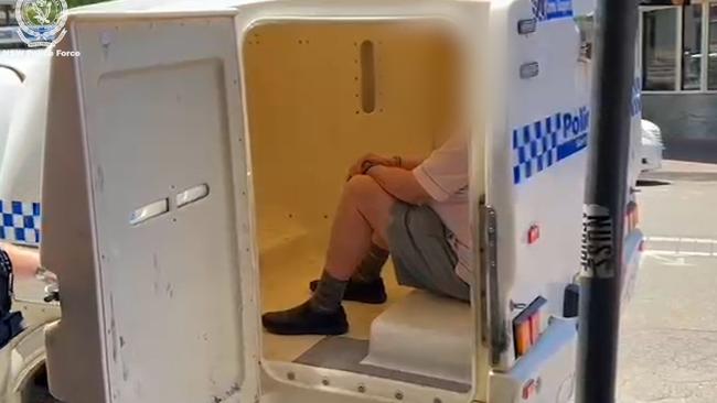 Catholic priest Guy Hartcher sits in the back of a police vehicle after his arrest at Pendle Hill. Picture: NSW Police