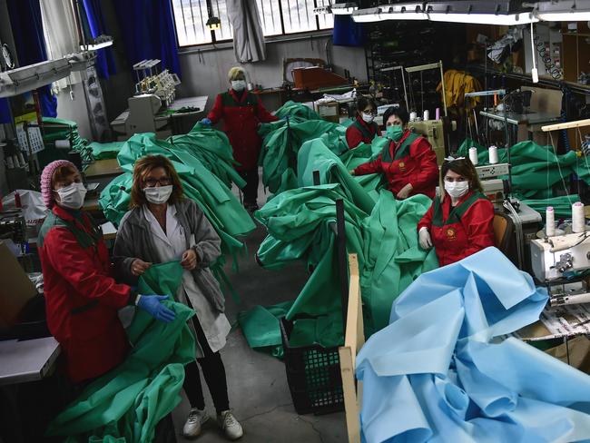 Volunteer workers in a clothing factory manufacturing firefighting gear, pose for a photo as they make hospital gowns for medical staff to protect them from the coronavirus, in Arnedo, northern Spain. Picture: AP