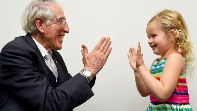 Professor Graeme Clark, the pioneer of the first bionic ear, enjoys a game of clap with Lily King 5 who has bilateral cochlear implants. Picture: Nicole Garmston