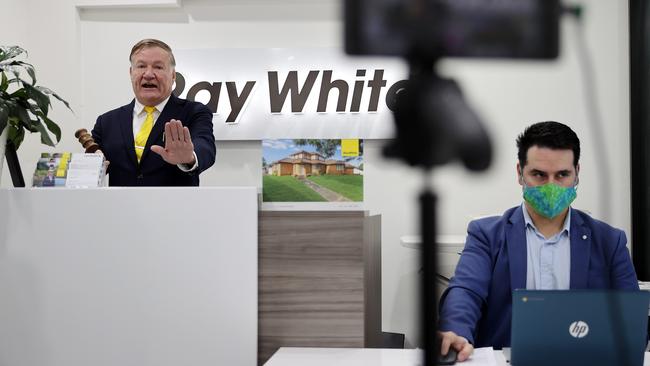 Auctioneer Paul Wright with Ray White Real Estate Agent Luis Garza, during a Virtual Auction at the Ray White office in Oatlands, in Sydney’s west on Saturday. Picture: Tim Hunter.