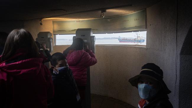 Tourists take photographs of the Chinese mainland from the bunker of an old Taiwan military observatory.