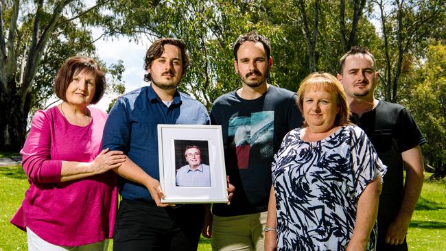 Carmel Schwartz, Jacob, Cameron, Sharon and Nathan Howard standing together with a framed photo of Peter Howard. Picture: Morgan Sette