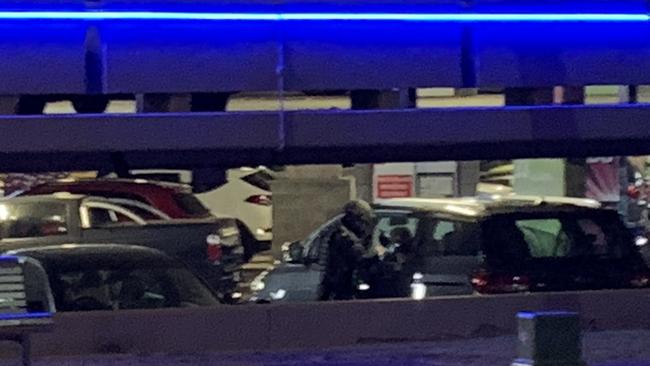 A bomb squad officer checking vehicles in the Bruce Bishop carpark.