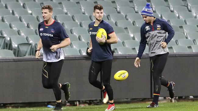 Josh Jenkins, Bryce Gibbs and Darcy Fogarty run laps of the Adelaide Oval. Picture: Sarah Reed