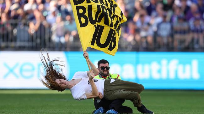 PERTH, AUSTRALIA - MAY 20: A pitch invader is tackled to the ground by a security guard during the round 10 AFL match between Walyalup/Fremantle Dockers and Geelong Cats at Optus Stadium, on May 20, 2023, in Perth, Australia. (Photo by Paul Kane/Getty Images)