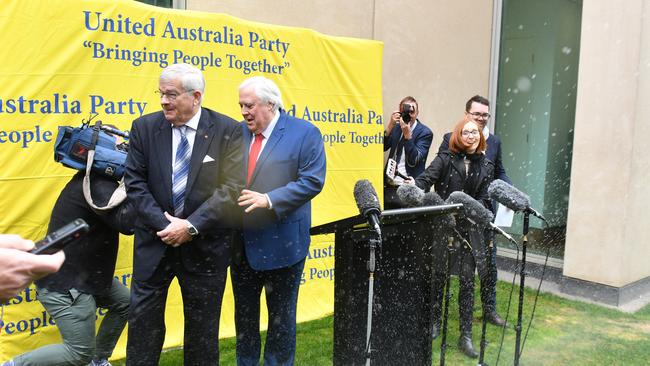 A sprinkler goes off under Clive Palmer’s lectern. Picture: AAP