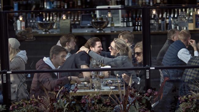 A couple hug and laugh as they have lunch in a restaurant in Stockholm, Sweden.