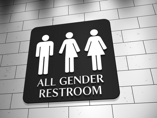 A sign on a wall for "All Gender Restroom" with symbols for men, trans and women. LGBT issue.