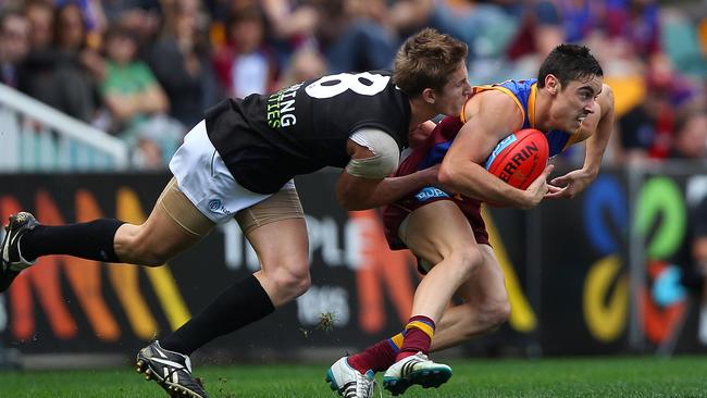 Jesse O'Brien is tackled by Port Adeliade’s Hamish Hartlett while playing for the Lions in 2011. Picture: Chris Hyde/Getty Images