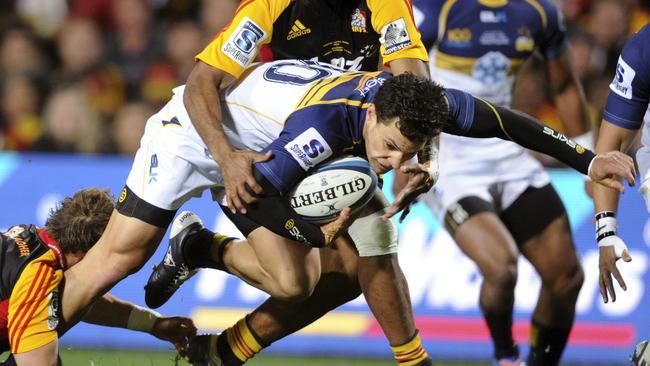 Brumbies' Matt Toomua, center front, is tackled by the Chiefs' Andrew Horrell, left, and Asaeli Tikoirotuma in the Super Rugby final match in Hamilton, New Zealand, Saturday, Aug. 3, 2013. (AP Photo/SNPA, Ross Setford) NEW ZEALAND OUT