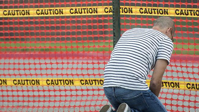 A man, who declined to be identified, kneels outside the Nebraska State Penitentiary. Picture: Eric Gregory/Lincoln Journal Star via AP