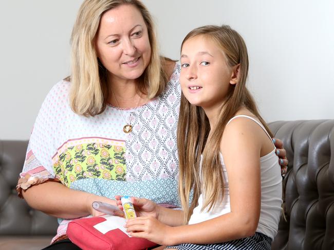 Sheree Johnson and her daughter Jazmine Bennett, 10, with her adrenaline-injecting EpiPen she must carry with her at all times. Photo: AAP/Steve Pohlner.