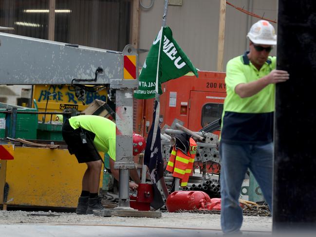 30/11/2016 A construction worker tends to a CFMEU flag on a crane at a  building site in South Yarra. Picture  David Geraghty / The Australian.