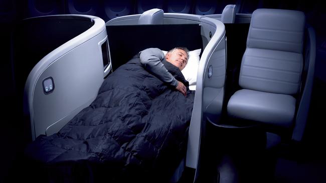 A passenger sleeping in business class on an Air New Zealand flight.