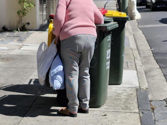 A woman going through a bin on Monday morning in St Kilda.