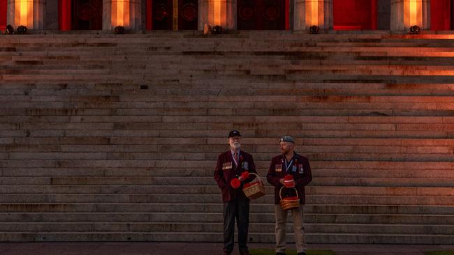 Volunteers prepare to hand poppies to the crowd. Picture: Getty Images