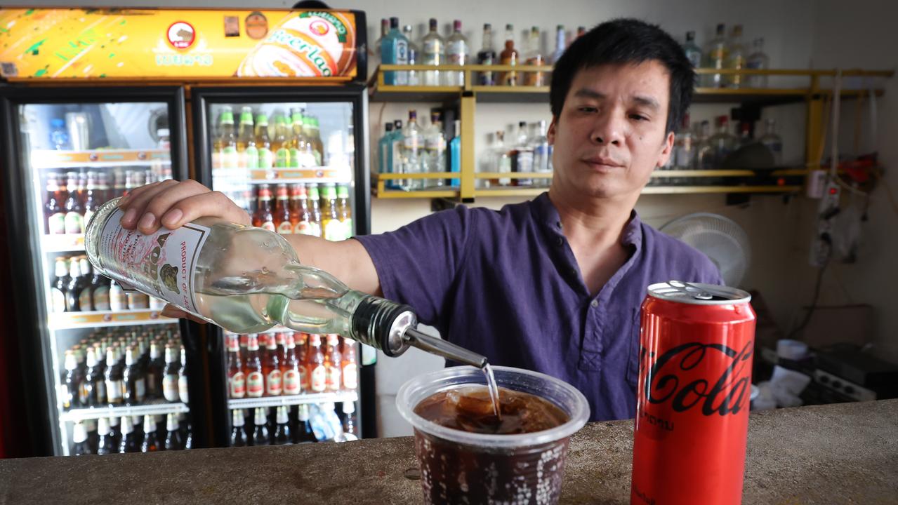 Nana Backpackers Hostel bartender Toan Van Vanng pours a vodka and Coke.