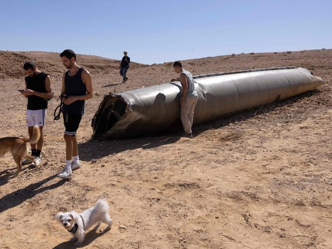 People visit the site of the remains of an Iranian missile in the Negev desert near Arad on October 3, 2024, in the aftermath of an Iranian missile attack on Israel. Israel vowed to make Iran "pay" for firing a barrage of missiles at its territory, with Tehran warning on October 2 it would launch an even bigger attack it is targeted. (Photo by MENAHEM KAHANA / AFP)