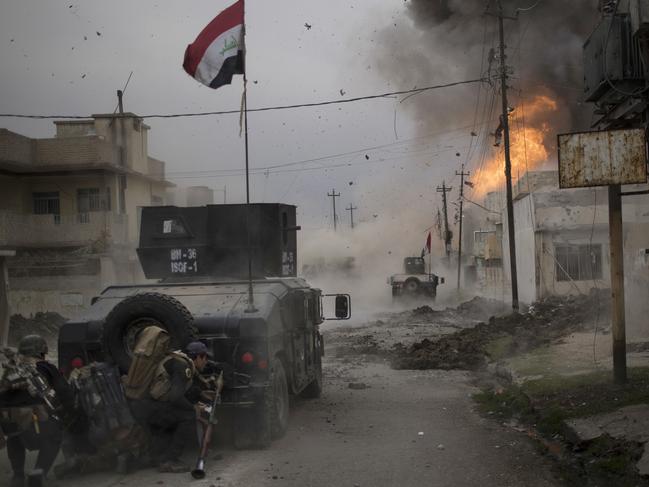 A car bomb explodes next to Iraqi special forces armoured vehicles as they advance towards Islamic State held territory in Mosul, Iraq. Picture: AP