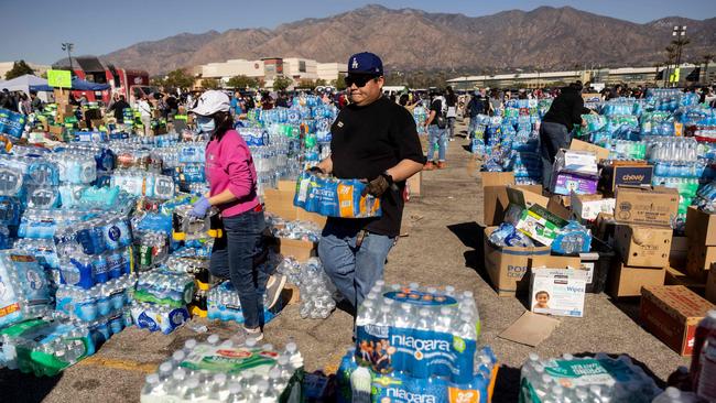 Volunteers carry water for evacuees from the Eaton Fire at a donation centre in Santa Anita Park, Arcadia, on Monday. Picture: AFP