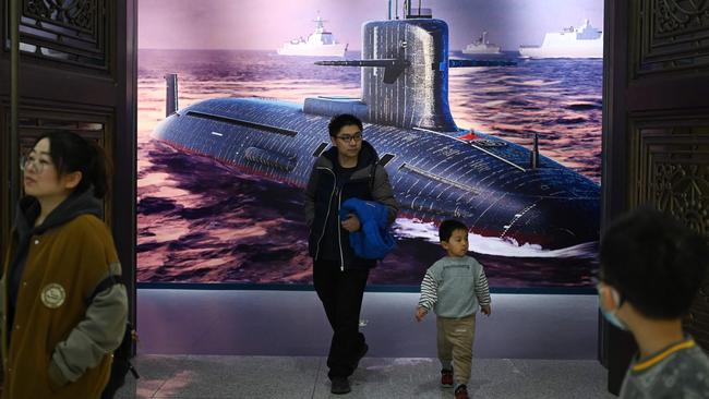 People walk past an illustration of a Chinese nuclear submarine at the Military Museum in Beijing on March 3. Picture: AFP