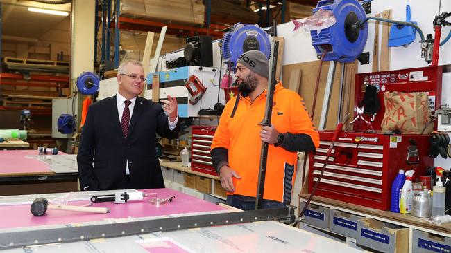 Prime Minister Scott Morrison speaks to Johnny Jackson as he is shown around his work area during a visit to the DisplayWise workshop in Miranda, Sydney. Picture: Mark Kolbe / Getty Images