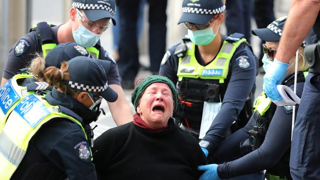 Police arrest a woman at an anti-vaxxer rally in Flagstaff Gardens. Picture: Alex Coppel