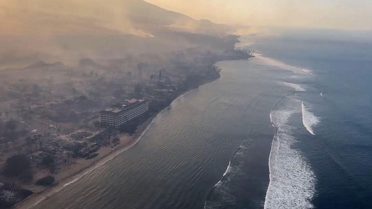 People fled into the water to escape the blaze. Picture: Richard Olsten / AFP