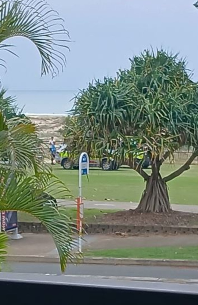 Paramedics and life savers treating a man in his sixties at Kirra Beach on Saturday morning after the skydiver broke his ankle upon landing. Picture: Facebook