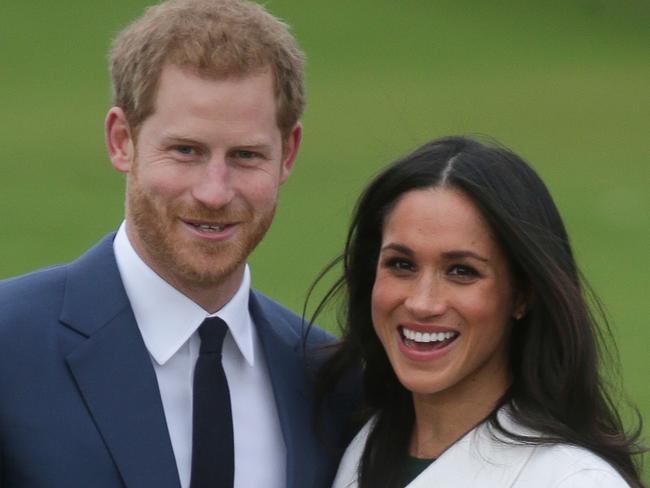 (FILES) This file photo taken on November 27, 2017 shows Britain's Prince Harry standing with his fiancée US actress Meghan Markle whilst they pose for a photograph in the Sunken Garden at Kensington Palace in west London, following the announcement of their engagement. Britain's Prince Harry and US actress Meghan Markle will marry on May 19 at St George's Chapel in Windsor Castle near London, Kensington Palace said on December 15, 2017. / AFP PHOTO / Daniel LEAL-OLIVAS