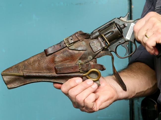 Snr Constable Don Buchanan holds a WW1 Colt Revolver issued to Canadian Servicemen. (AAP Image/Sue Graham)