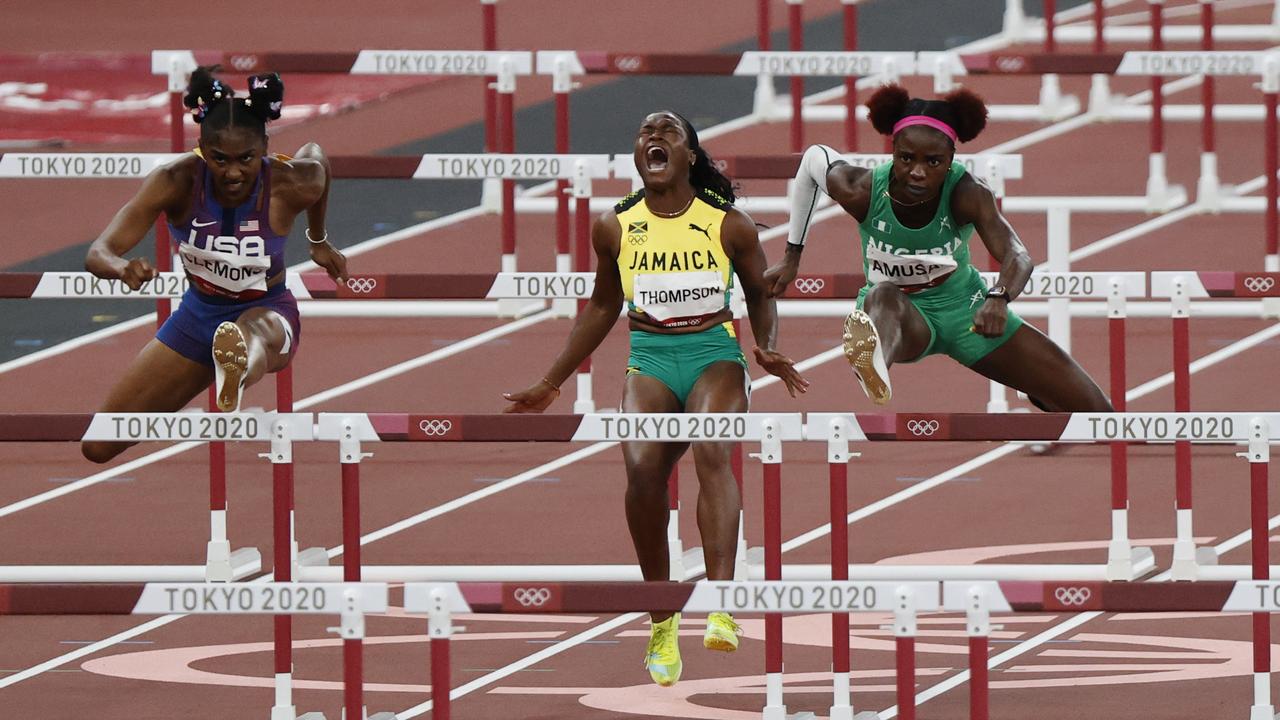 Jamaica’s Yanique Thompson screams after taking out a hurdle, as Nigeria’s Tobi Amusan (right) went on to win the semifinal of the women’s 100mhHurdles. Picture: Alex Coppel