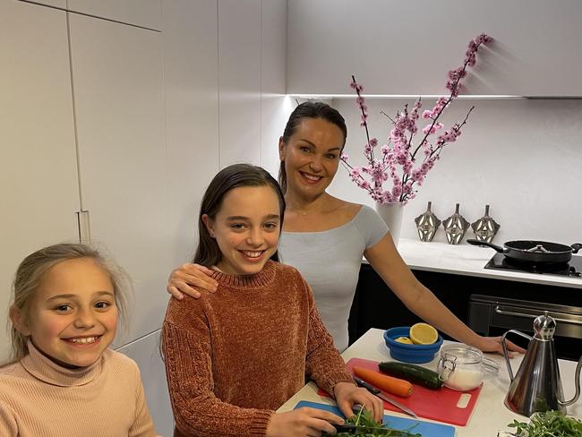 Patricia Cencigh with daughters Charlize, 13 (centre) and Alegra, 10 cooking together at home in Enmore, Sydney.