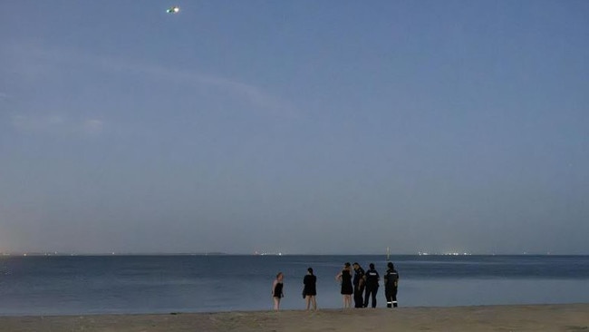 A drone is used to help in the recovery of a pair of paddle boarders at Eastern Beach in Geelong as police speak to concerned people. Photo: Supplied.,