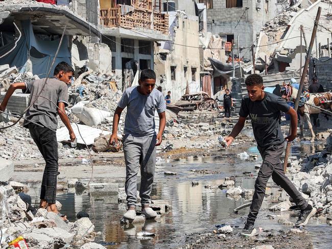 Boys walk on dry bricks to traverse a puddle of sewage water past mounds of trash and rubble along a street in the Jabalia camp for Palestinian refugees in the northern Gaza Strip. Picture: AFP